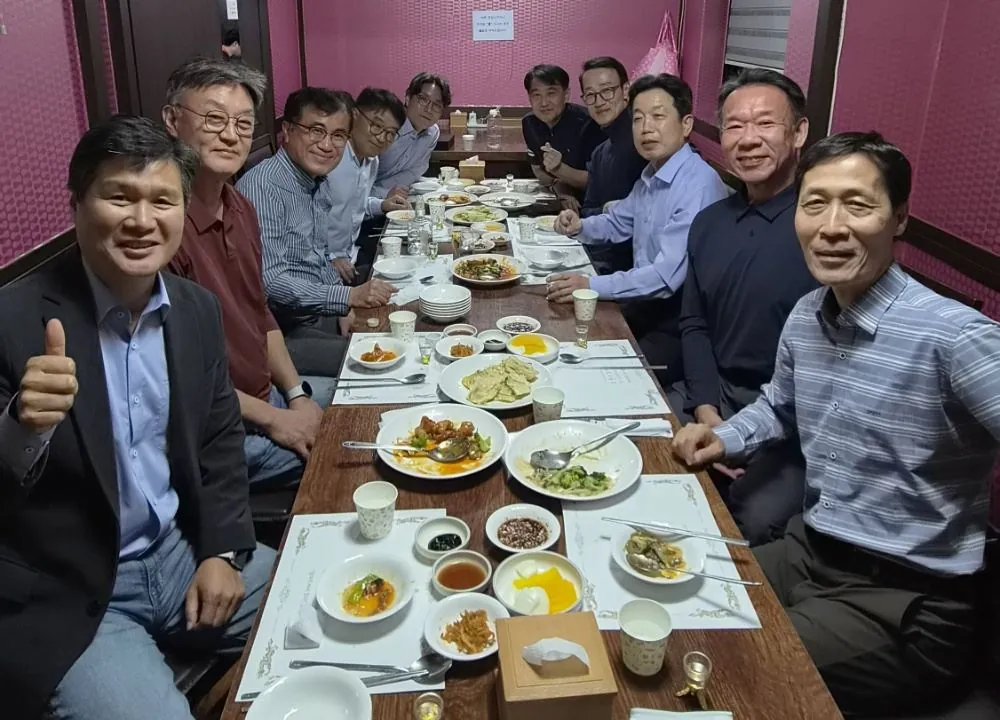 북정회 회원 10명이 중국집 긴 테이블에 둘러앉아 웃고 있다