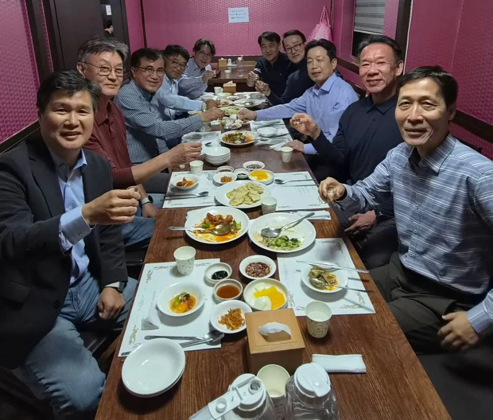 열 명이 잔을 높이 든 장면